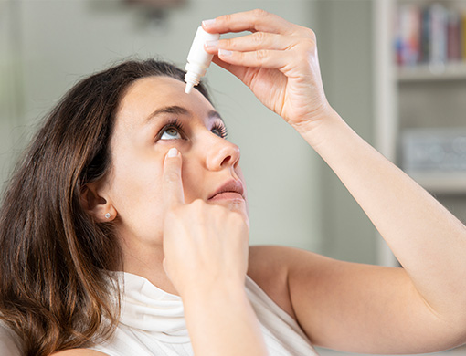 Woman experiencing dry eye and using eye drops